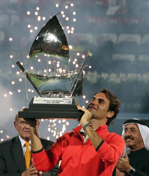 Roger Federer alza al cielo il trofeo: dietro di lui i fuochi d&#39;artificio. Afp